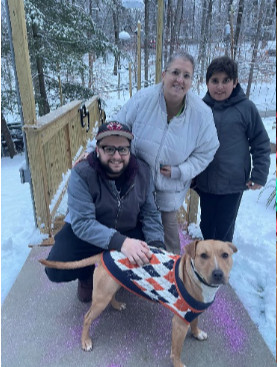 photo of dog named Milo in sweater with 3 volunteers